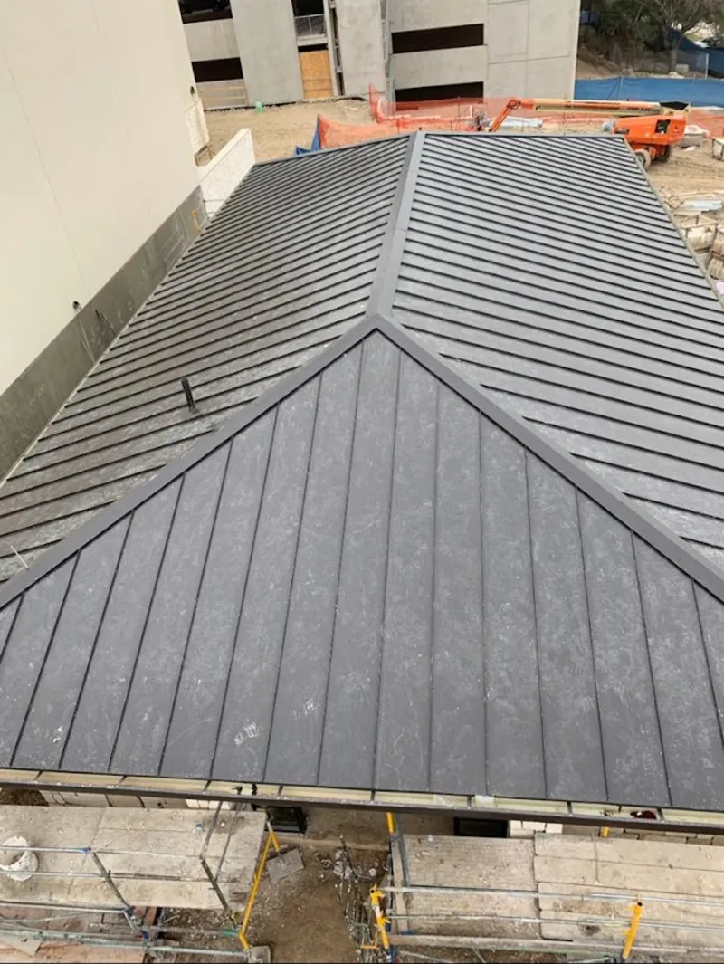 Commercial metal roof construction with crane equipment in Cheviot